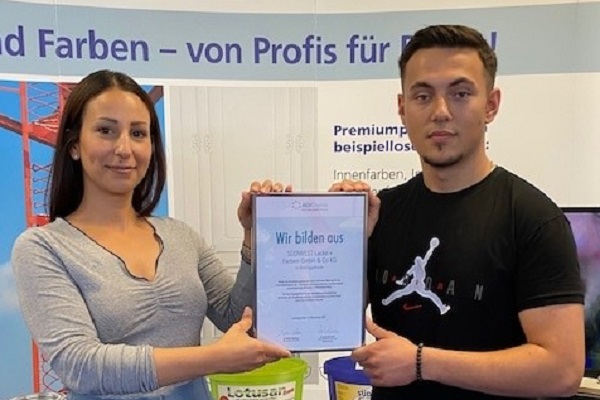 Frau Böcher und Azubi Kazim nahmen die Urkunde strahlend entgegen.